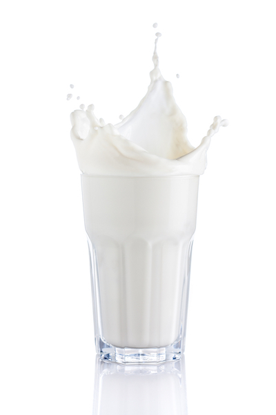 splash of milk in a glass on white background